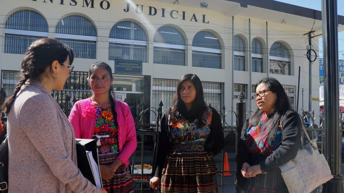 Four female members of the activist group COPA stand talking outside a court