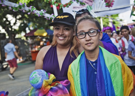 2 people with rainbow flags at a LGBTQ parade in Philippines