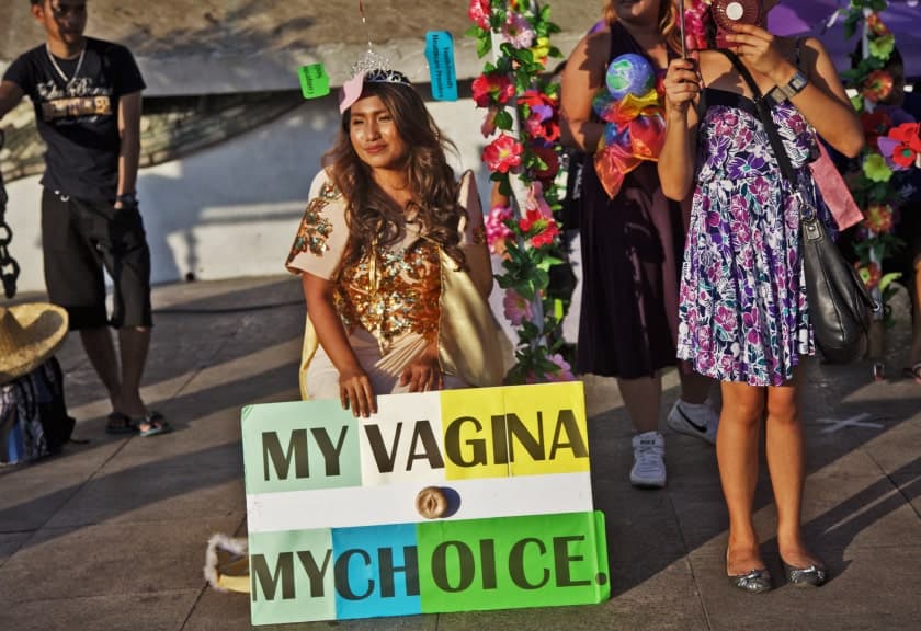 Woman in Philippines protesting for women's rights holds a sign reading 'my vagina my choice'