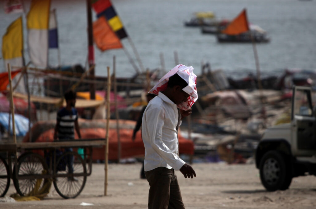 People walk during heat-wave conditions at the bank of the Ganges River in Prayagraj, India.