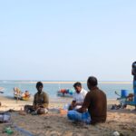 A group of fisherfolk weave and fix nets on a beach in Alamparai, Tamil Nadu, India.